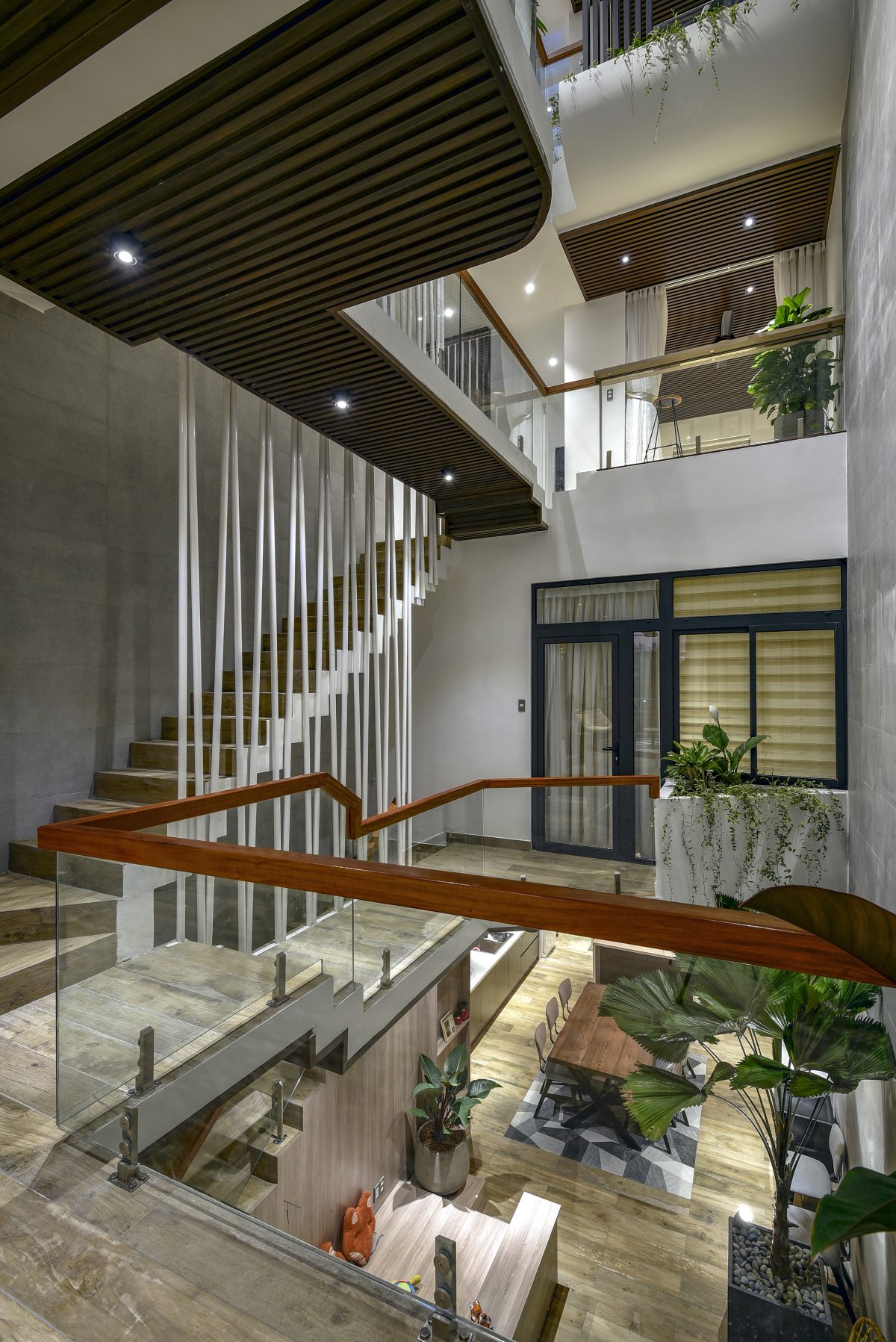 Giải pháp đầu tiên là tạo một không gian thông tầng ở chính giữa nhà, khoảng 11 m2. Cộng thêm diện tích dành cho cầu thang, cả không gian giao thoa là hơn 20 m2, chiếm gần 1/4 diện tích đất xây nhà.